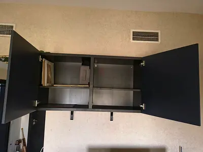 Wall-mounted black storage cabinet with double doors - good condition