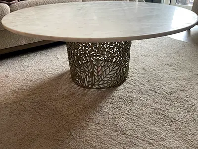 Round marble-top coffee table with decorative metal base