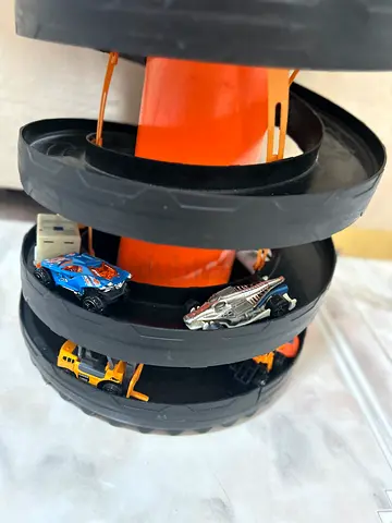 Hot Wheels-style multi-level toy car racetrack with small diecast cars