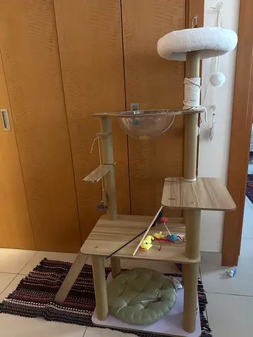 Wooden multi-level cat tree with scratching posts and toys