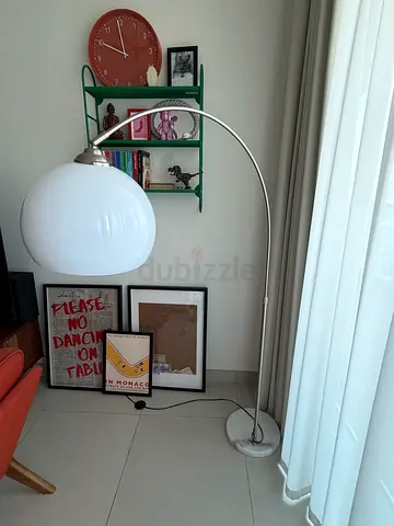 White arc floor lamp with glass globe shade