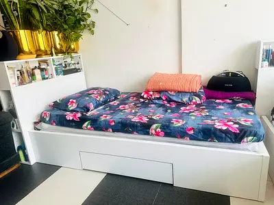 2 white beds with storage and white headboards storage.