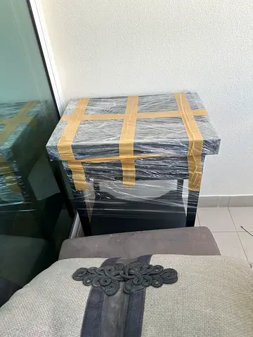 Two black stands with drawers wrapped and ready for pickup.