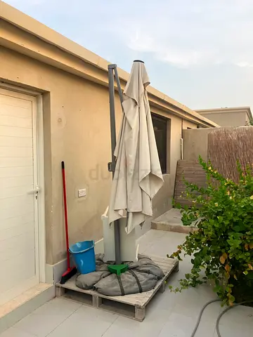 Used beige cantilever/offset patio umbrella with base