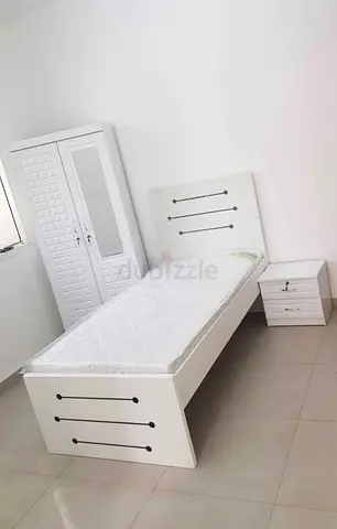 Single white wooden bed with mattress, matching wardrobe and bedside table