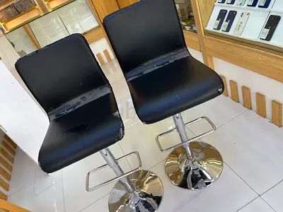 Pair of black swivel bar stools with chrome bases — used