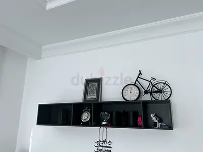 Wall-mounted black shelf unit with 5 compartments