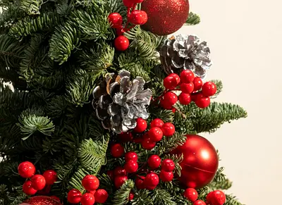 Decorated Christmas tree with red berries and silver pine cones