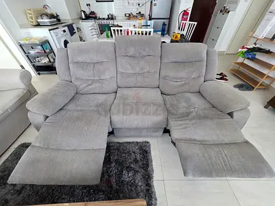 Three-seater grey fabric recliner sofa in good used condition