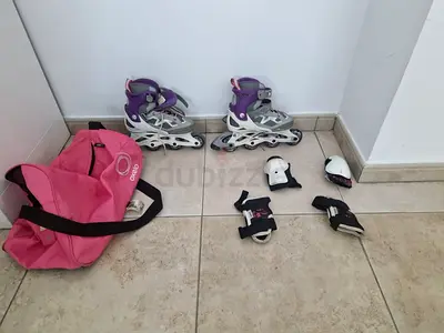 Kids adjustable inline skates with protective gear and pink bag - good condition