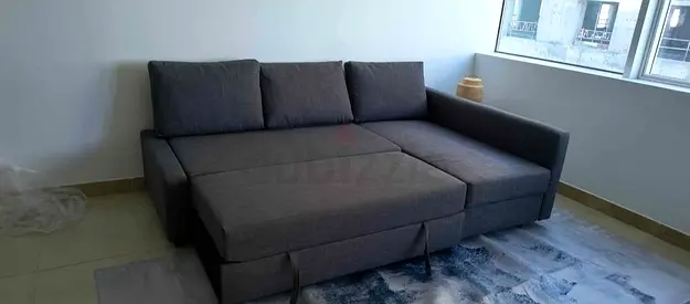 Dark grey L-shaped sofa bed with storage - good condition