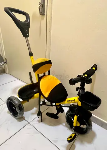Yellow baby tricycle with push handle and storage tray