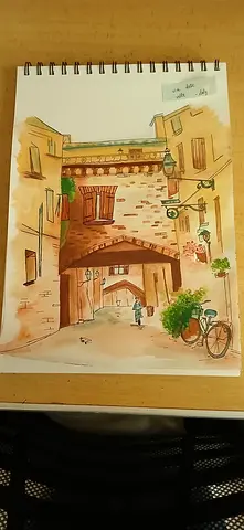 Hand-painted watercolor sketch of a rustic street scene (spiral sketchbook page)