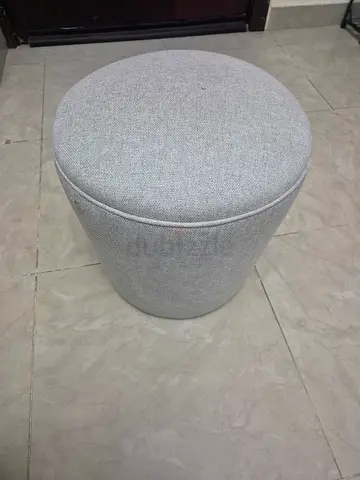Light grey round upholstered ottoman / stool
