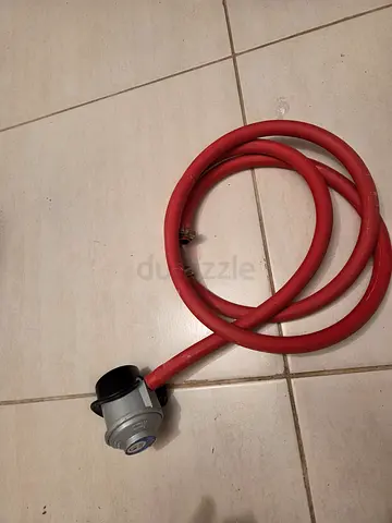 Used LPG gas regulator with red hose