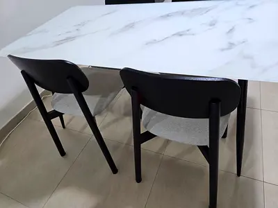White marble-effect dining table with 4 black dining chairs