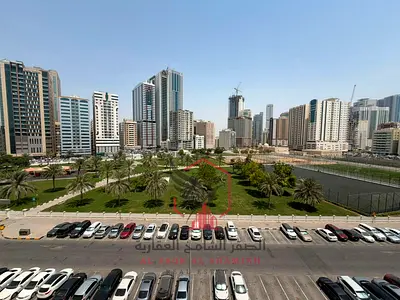 Panoramic garden view, secure check, larger two-bedroom apartment with living room, free parking, built-in wardrobes, and balcony for rent in Al Majaz