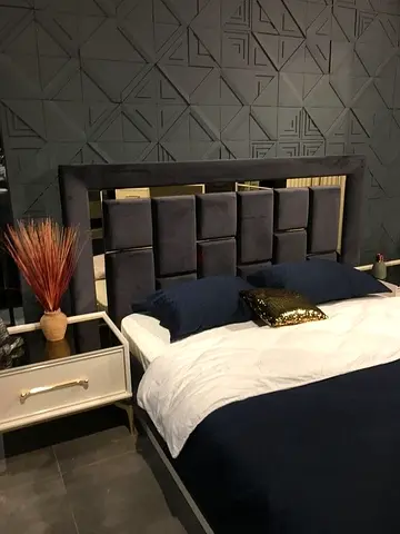 Modern upholstered king-size bed with padded headboard and mirrored accents
