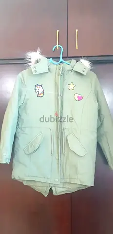 Green children's winter parka jacket with hood and patches - size not specified