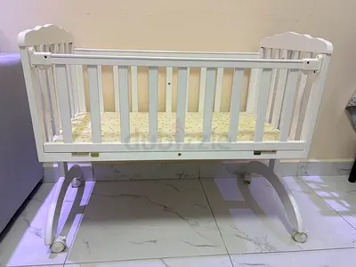 White wooden baby crib with wheels