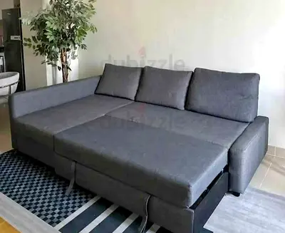 Grey L-shaped sofa bed with storage — good condition