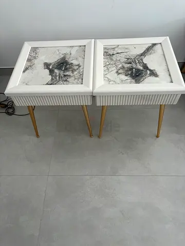 Pair of white bedside nightstands with marble-style panels and gold legs