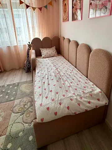 Single toddler bed with upholstered scalloped headboard