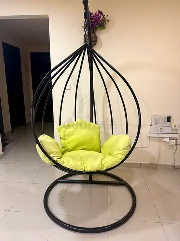 Black metal hanging egg chair with lime cushions