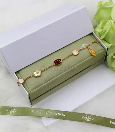 Van Cleef & Arpels style gold-tone charm bracelet (shell, clover, leaf motifs)