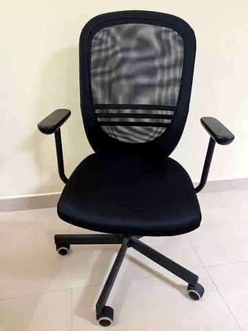Black mesh ergonomic office chair with armrests and wheels