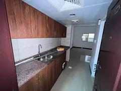 Spacious studio apartment with a semi-detached kitchen and built-in wardrobes, priced at AED 18,000 