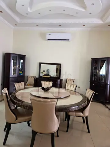 Marble-top round dining table with 8 leather chairs and matching cabinets