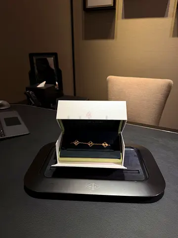 Delicate gold-tone Van Cleef bracelet set with quatrefoil motifs in original box. Never worn.