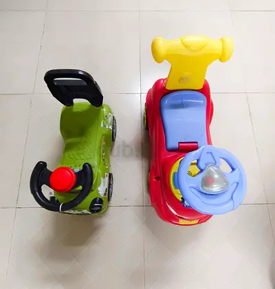 Two ride-on toddler cars (red and green) - good used condition