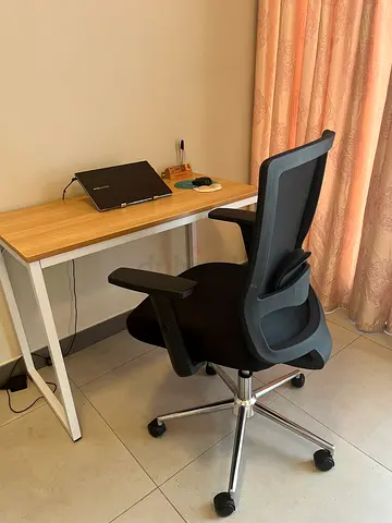 Ergonomic black office chair with swivel base from Mahamayi and computer Table from Pan Home