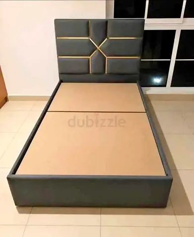 Double grey upholstered bed frame with padded headboard