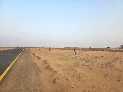 Two industrial plots for sale in Al Qasimia City, Phase 4. One is a corner plot on two streets, and the other is on a single street.