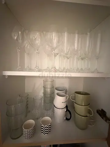 Kitchen glassware set in cabinet — wine glasses, mugs and tumblers