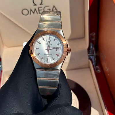 This watch appears to be an Omega Constellation with a stainless steel and ros
