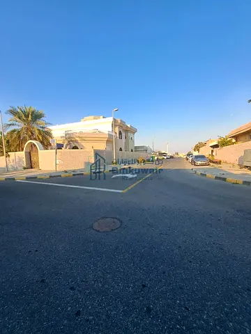 House for sale in Al-Jazzat, situated on two paved streets and equipped with two official utility meters.