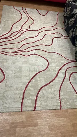 Light beige rug with red abstract wave pattern - good used condition
