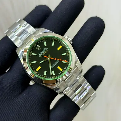 This Rolex Milgauss (Ref. features a distinctive black dial paired with a signature green sapphire c