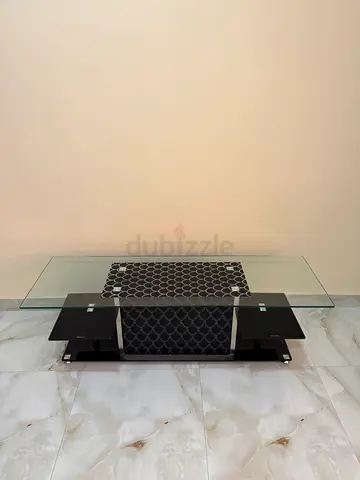 Modern glass coffee table with black base - good condition