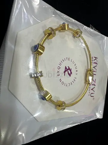Onam Gold-tone charm bracelet with bead accents - unused, in packaging
