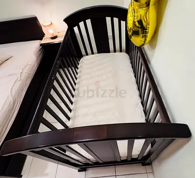 Juniors wood baby crib/cot bed in dark brown finish with almost new mattress.