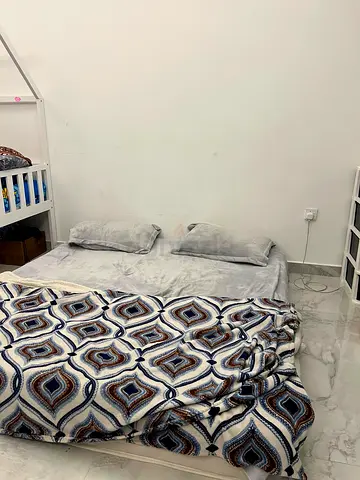 Queen size mattress on floor with grey bedding and patterned blanket - good condition