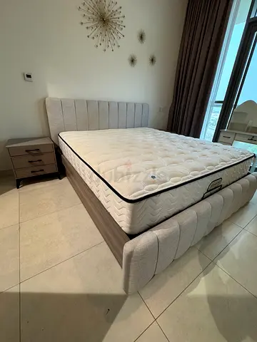 Queen upholstered bed frame with mattress and matching bedside table - good condition