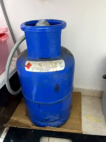 Used blue LPG gas cylinder with regulator & pipe (full/needs refill) - sturdy condition
