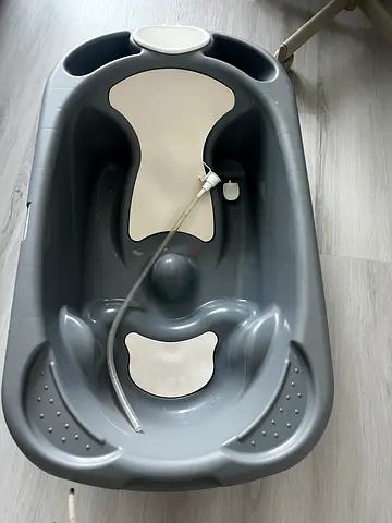 Grey baby bathtub with built-in plug and infant support