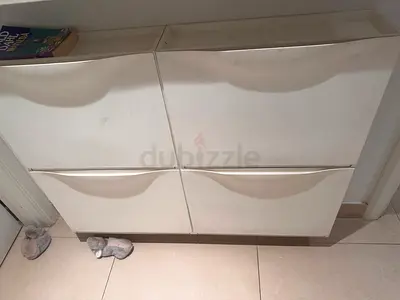 White wall-mounted shoe cabinet with four drop-down compartments